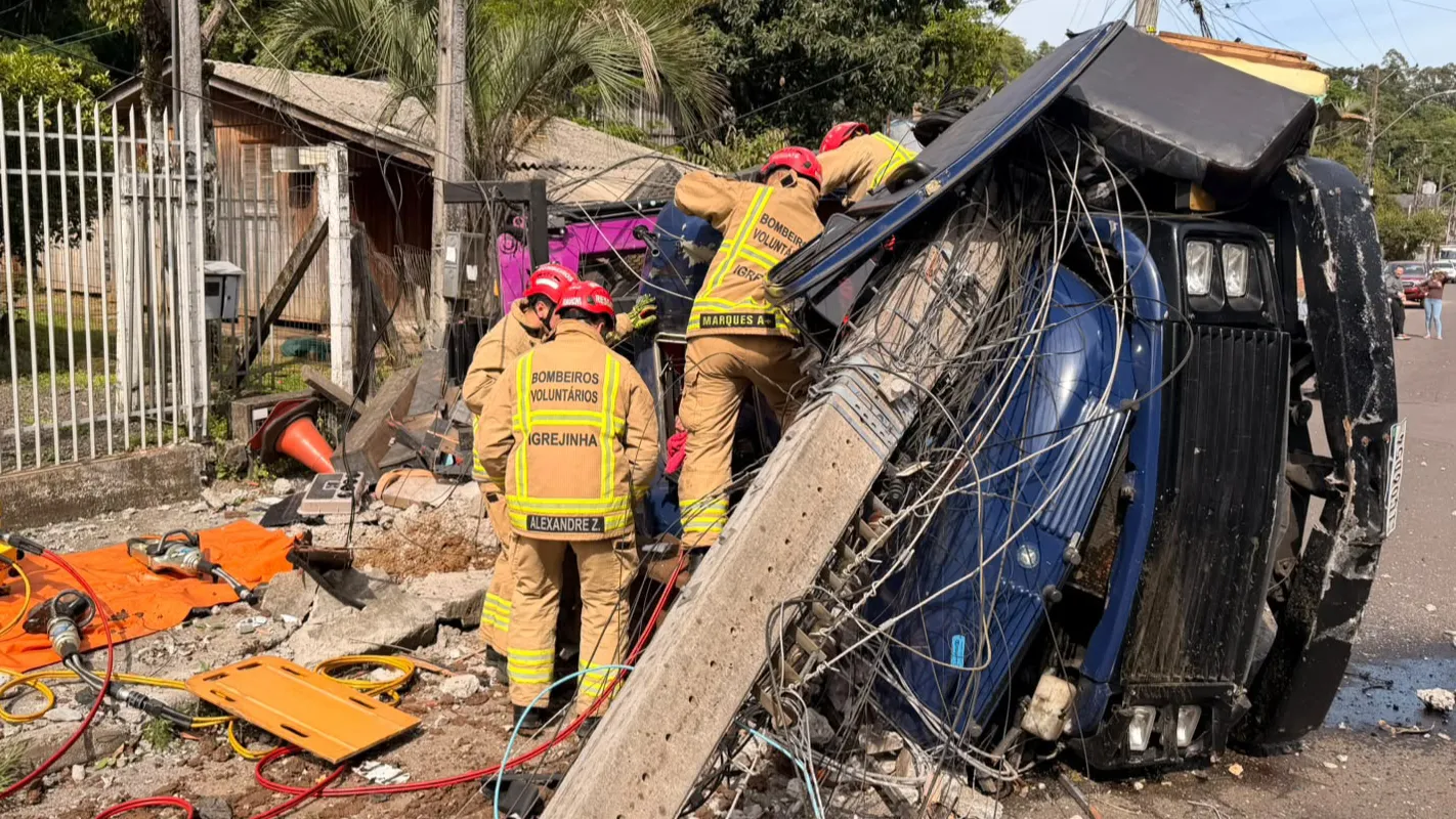Motorista preso em cabine após caminhão tombar e destruir poste e casa em Igrejinha